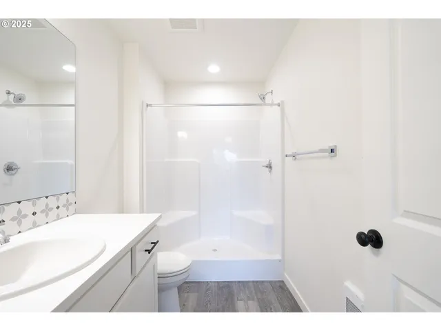 a bathroom with a sink a toilet a shower and a mirror