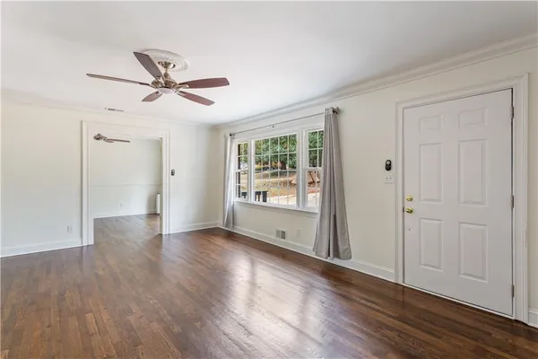 a view of empty room with wooden floor and window