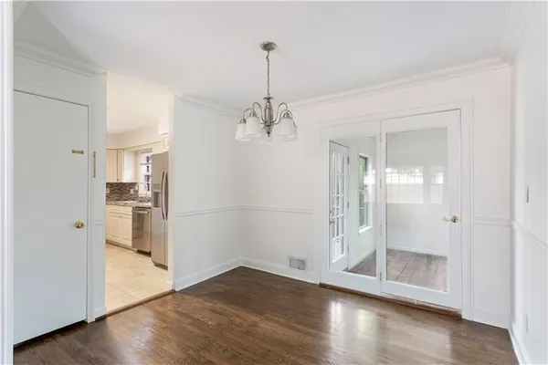 a view of a room with wooden floor white walls and cabinet