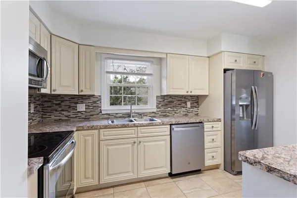 a kitchen with stainless steel appliances granite countertop a sink stove and refrigerator