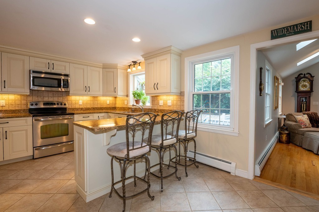 24 Hawthorn Road Marblehead, MA 01945 - Photo 12 of 30 a kitchen with stainless steel appliances granite countertop a stove top oven a sink a counter top space cabinets and a window
