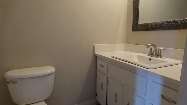 a bathroom with a toilet sink and mirror
