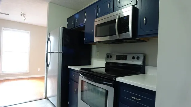 a kitchen with stainless steel appliances granite countertop a stove microwave and refrigerator