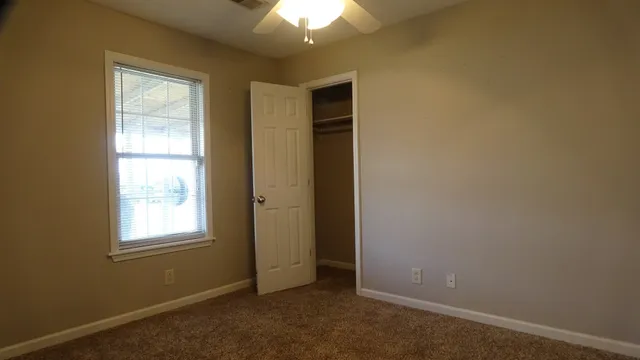 an empty room with windows and closet
