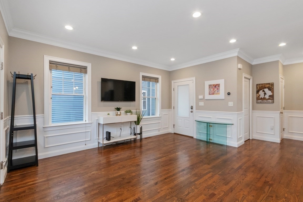 141 Ash Street, Unit 1 Waltham, MA 02453 - Photo 11 of 31 a view of a livingroom with furniture a flat screen tv and wooden floor