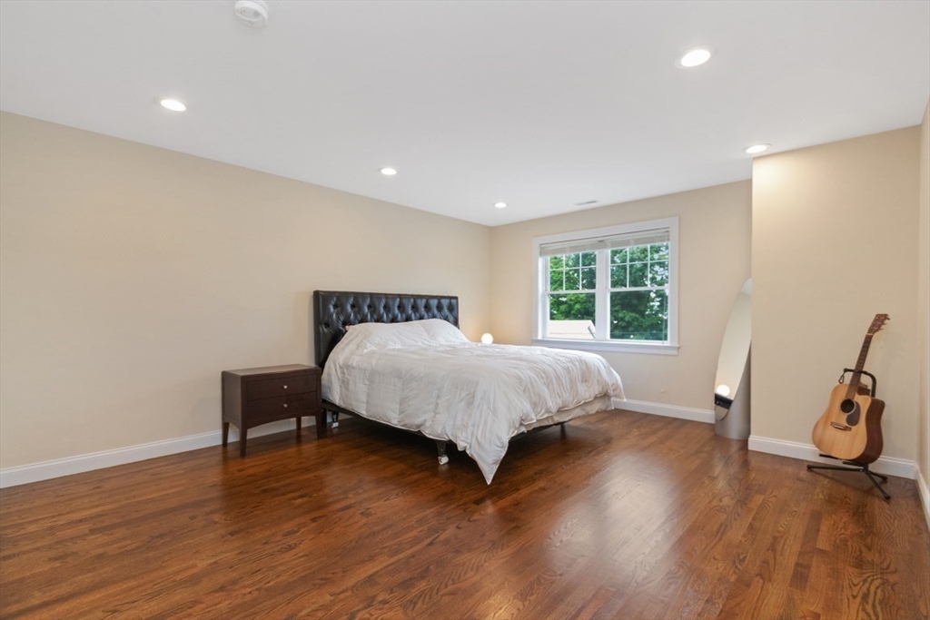 141 Ash Street, Unit 1 Waltham, MA 02453 - Photo 12 of 31 a bedroom with a bed and wooden floor