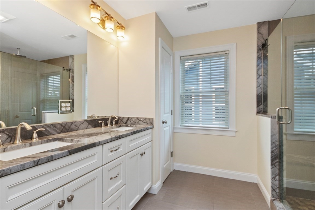 141 Ash Street, Unit 1 Waltham, MA 02453 - Photo 16 of 31 a bathroom with a granite countertop sink mirror and a shower