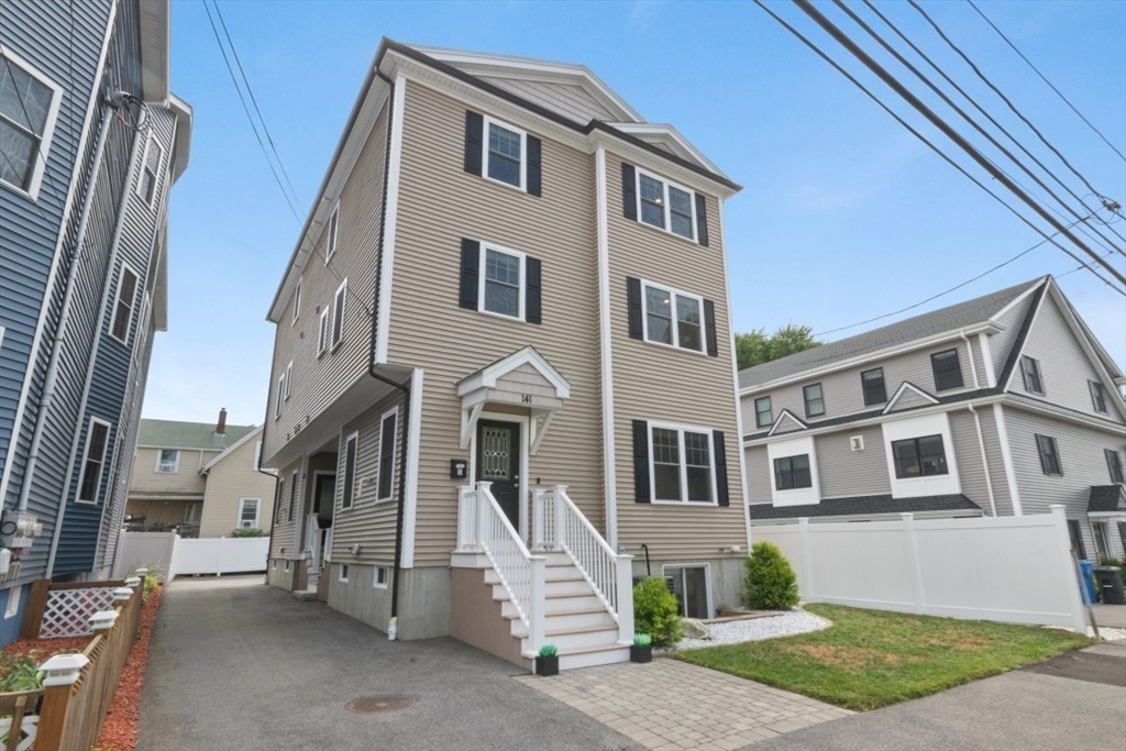 141 Ash Street, Unit 1 Waltham, MA 02453 - Photo 2 of 31 a front view of a house with a yard