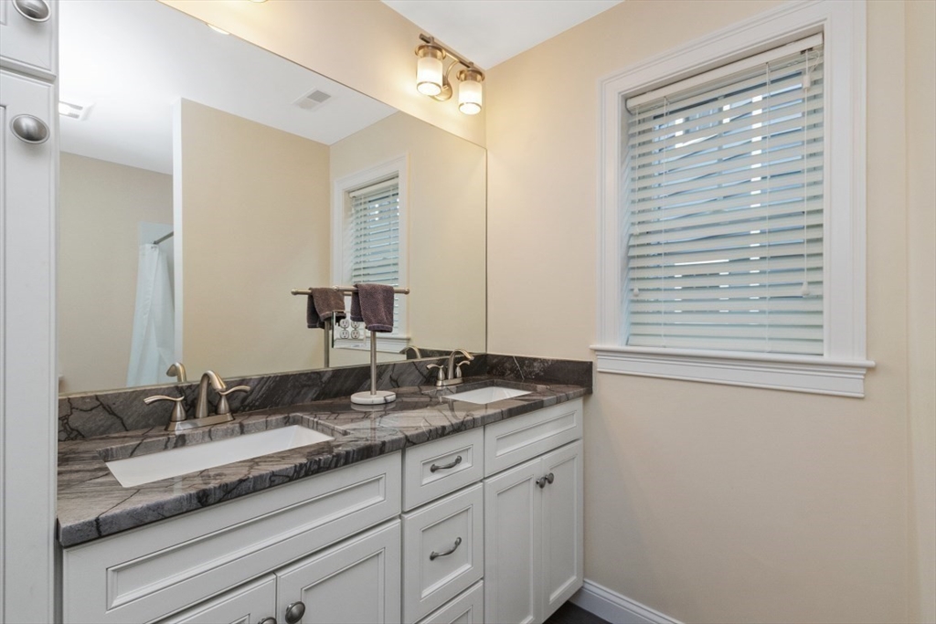 141 Ash Street, Unit 1 Waltham, MA 02453 - Photo 22 of 31 a bathroom with a granite countertop sink and a mirror