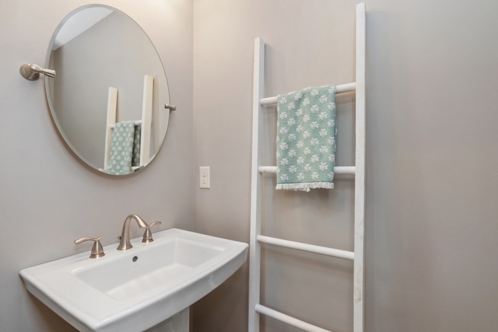 141 Ash Street, Unit 1 Waltham, MA 02453 - Photo 25 of 31 a bathroom with a sink a mirror and a toilet