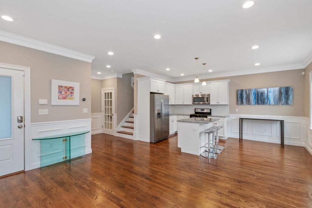 141 Ash Street, Unit 1 Waltham, MA 02453 - Photo 6 of 31 a kitchen with stainless steel appliances kitchen island granite countertop a refrigerator and a stove top oven