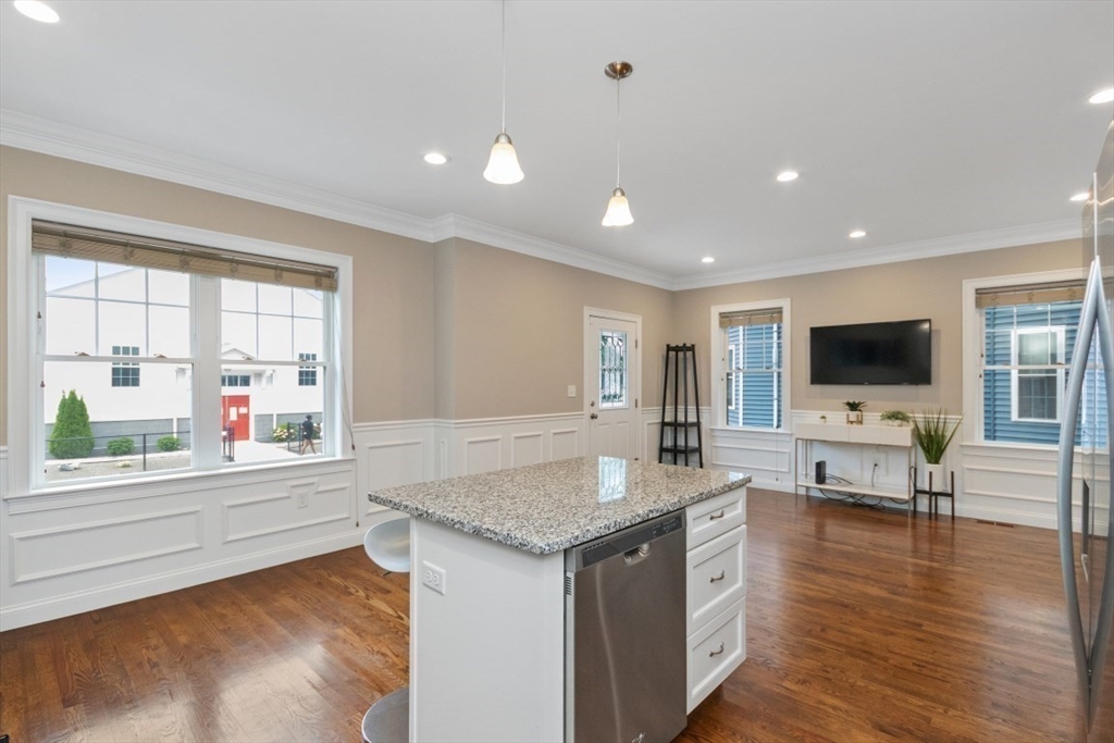 141 Ash Street, Unit 1 Waltham, MA 02453 - Photo 8 of 31 a living room with stainless steel appliances granite countertop a couch and a flat screen tv