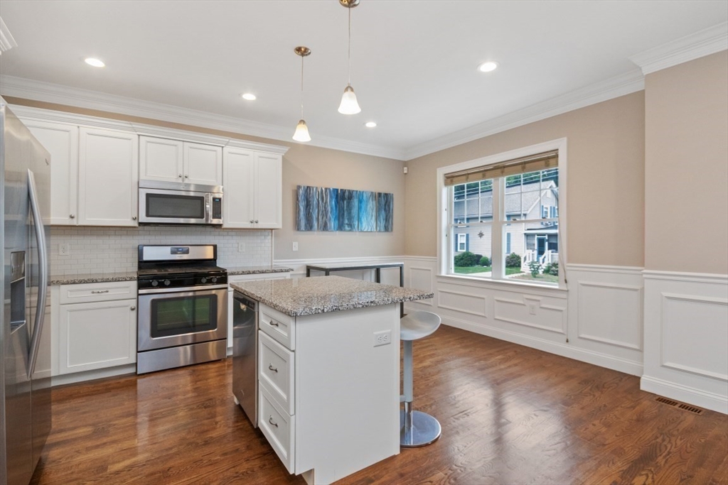 141 Ash Street, Unit 1 Waltham, MA 02453 - Photo 9 of 31 a kitchen with stainless steel appliances granite countertop a stove a sink and a refrigerator