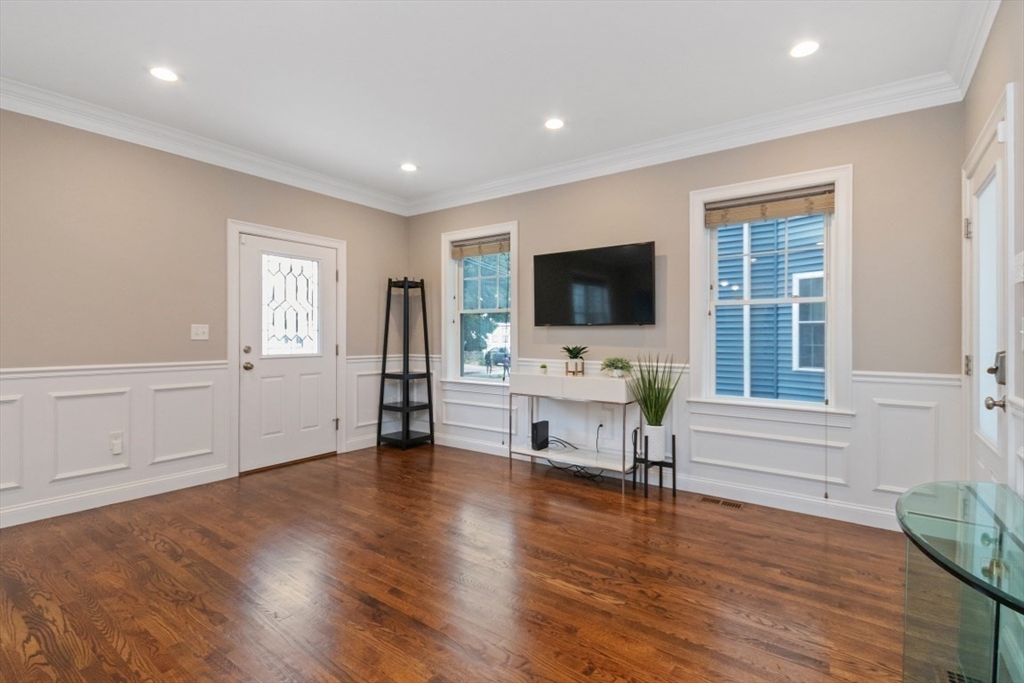 141 Ash Street, Unit 1 Waltham, MA 02453 - Photo 10 of 31 a living room with furniture and a flat screen tv