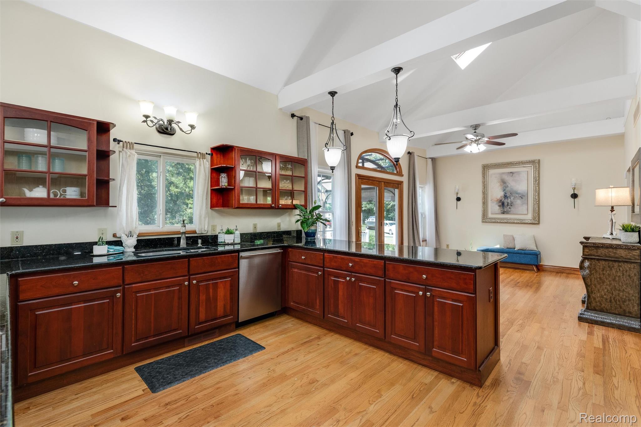 21280 Merriman Road New Boston, MI 48164 - Photo 24 of 65 Kitchen featuring wood-finish flooring, dark wood cabinetry, and a dark stone countertop