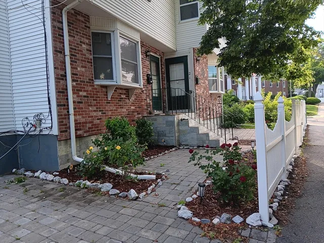 a front view of a house with outdoor seating and plants