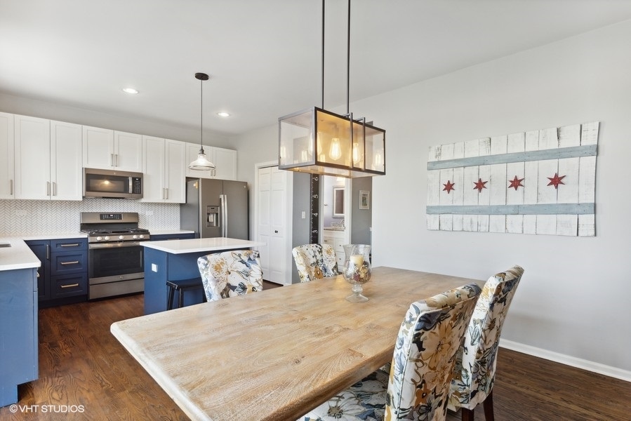 1052 Kufrin Way Lombard, IL 60148 - Photo 5 of 16 a kitchen with stainless steel appliances granite countertop a dining table chairs refrigerator and microwave