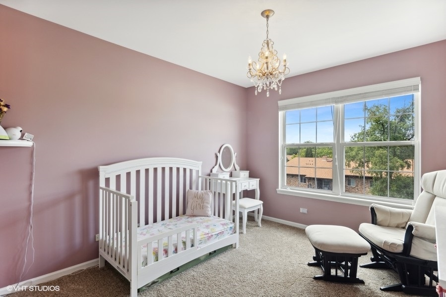 1052 Kufrin Way Lombard, IL 60148 - Photo 10 of 16 a bedroom with a bed and a chandelier