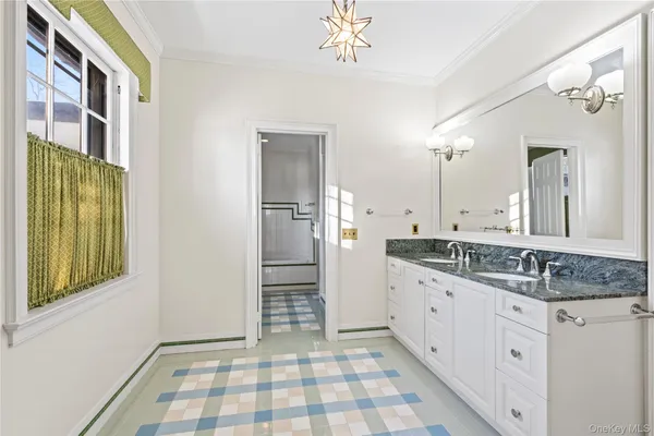 a bathroom with a granite countertop sink a mirror and a shower
