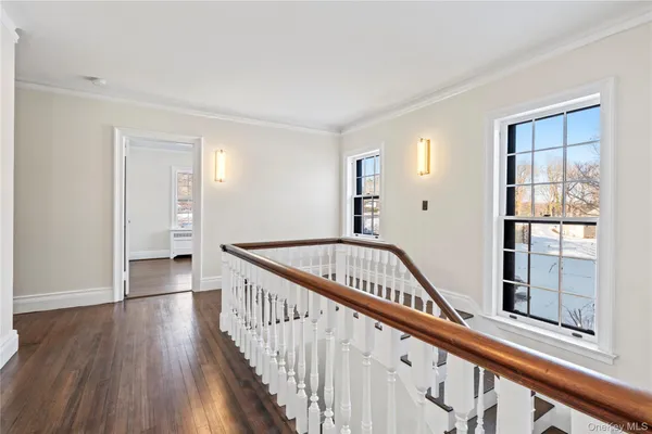 a view of a hallway with wooden floor and entryway