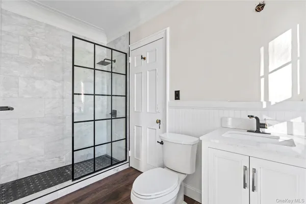 a bathroom with a sink toilet vanity and shower