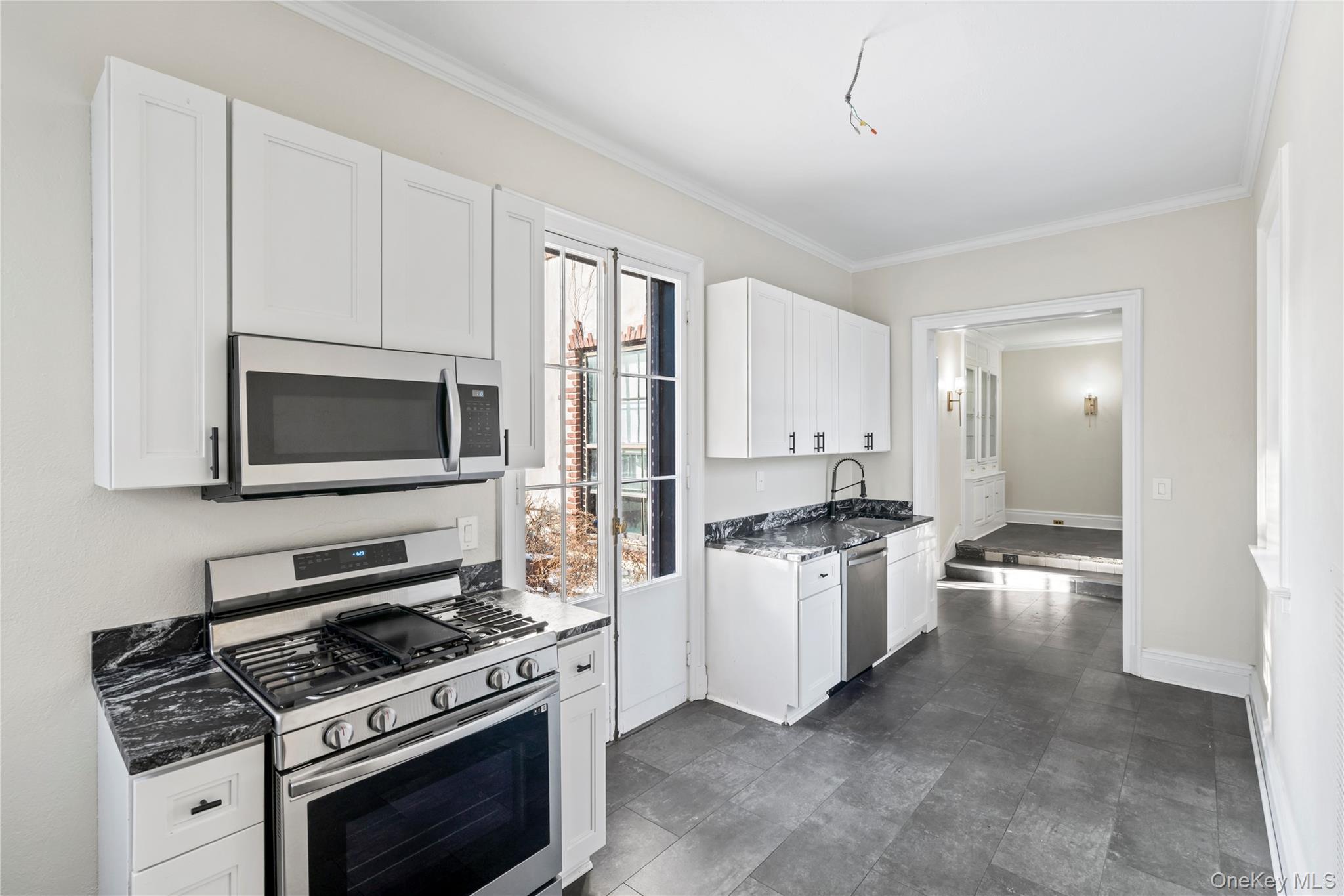 203 Store Hill Road Old Westbury, NY 11568 - Photo 34 of 50 a kitchen with stainless steel appliances a stove a microwave and cabinets