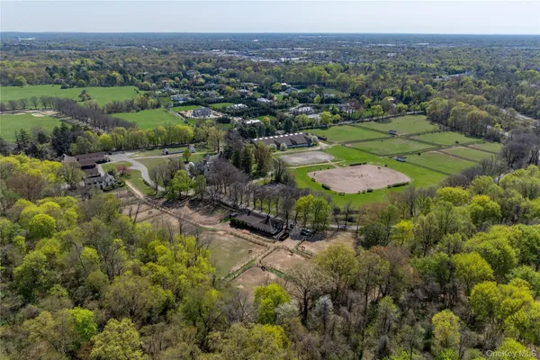 an aerial view of residential house with outdoor space and trees all around