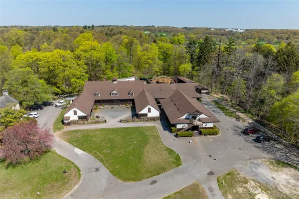 an aerial view of a house with swimming pool and mountains
