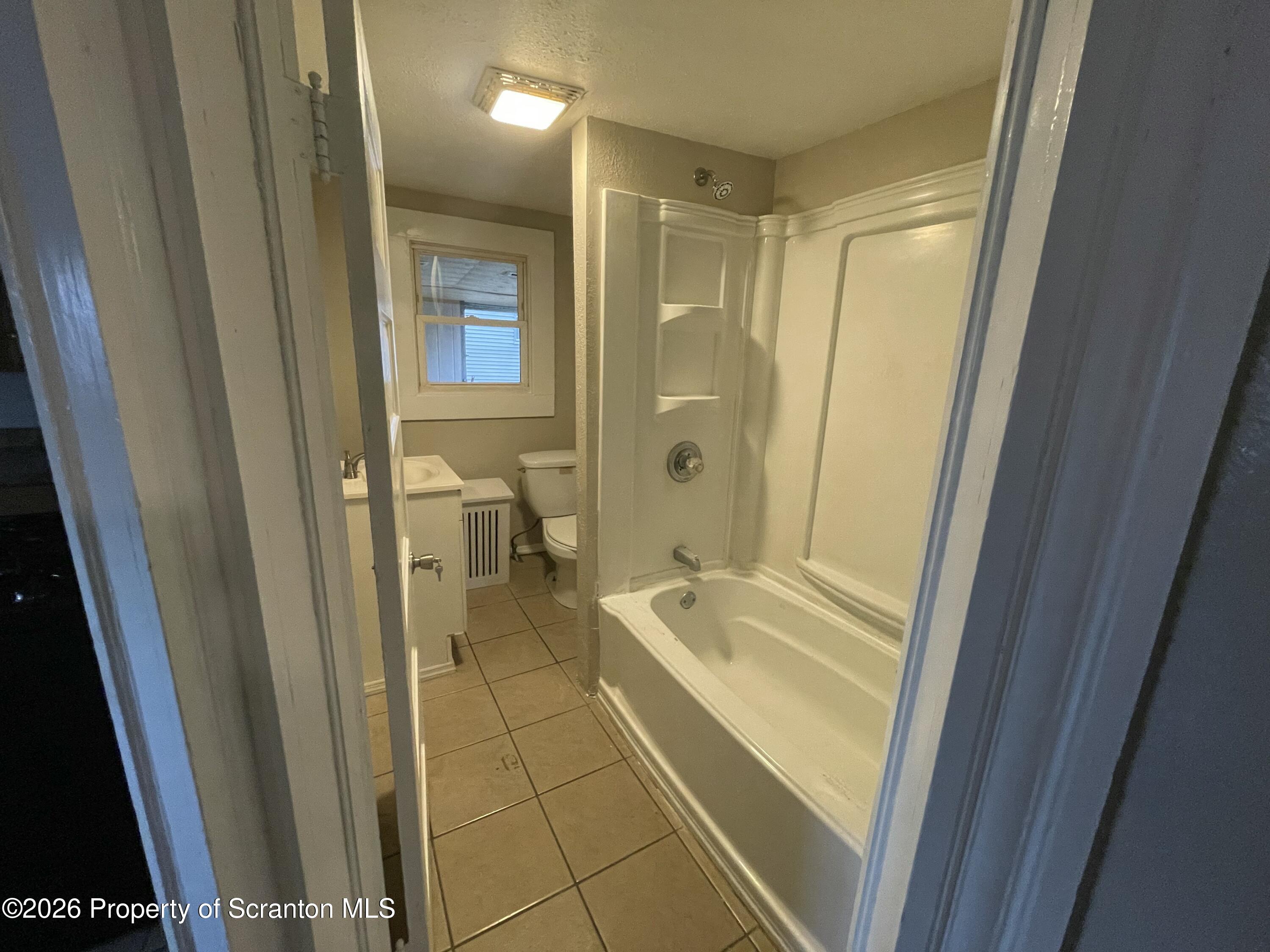 401 Putnam Street Scranton, PA 18508 - Photo 19 of 29 a bathroom with a tub a sink and a glass door