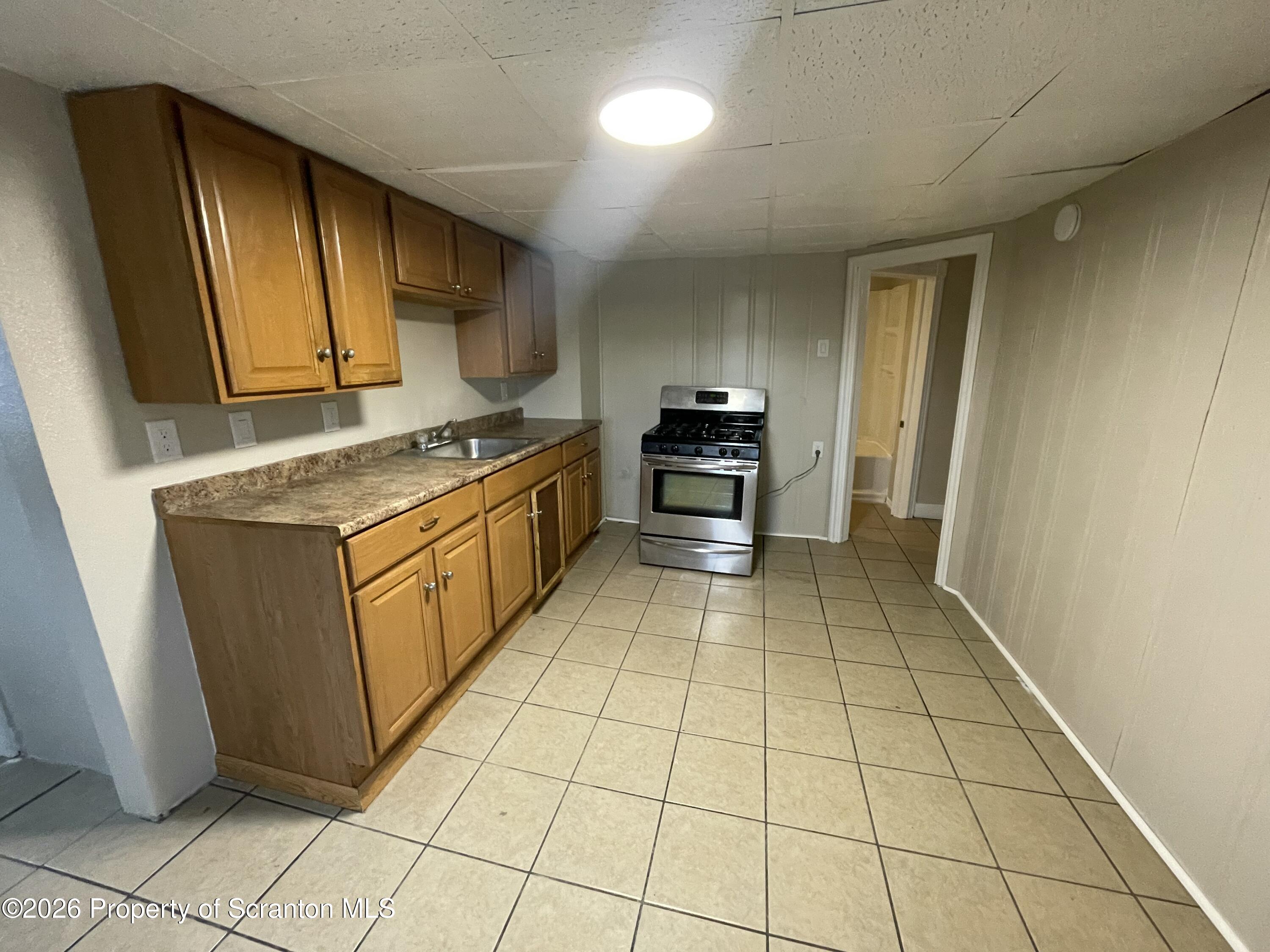 401 Putnam Street Scranton, PA 18508 - Photo 23 of 29 a kitchen with stainless steel appliances granite countertop a stove a sink and a microwave