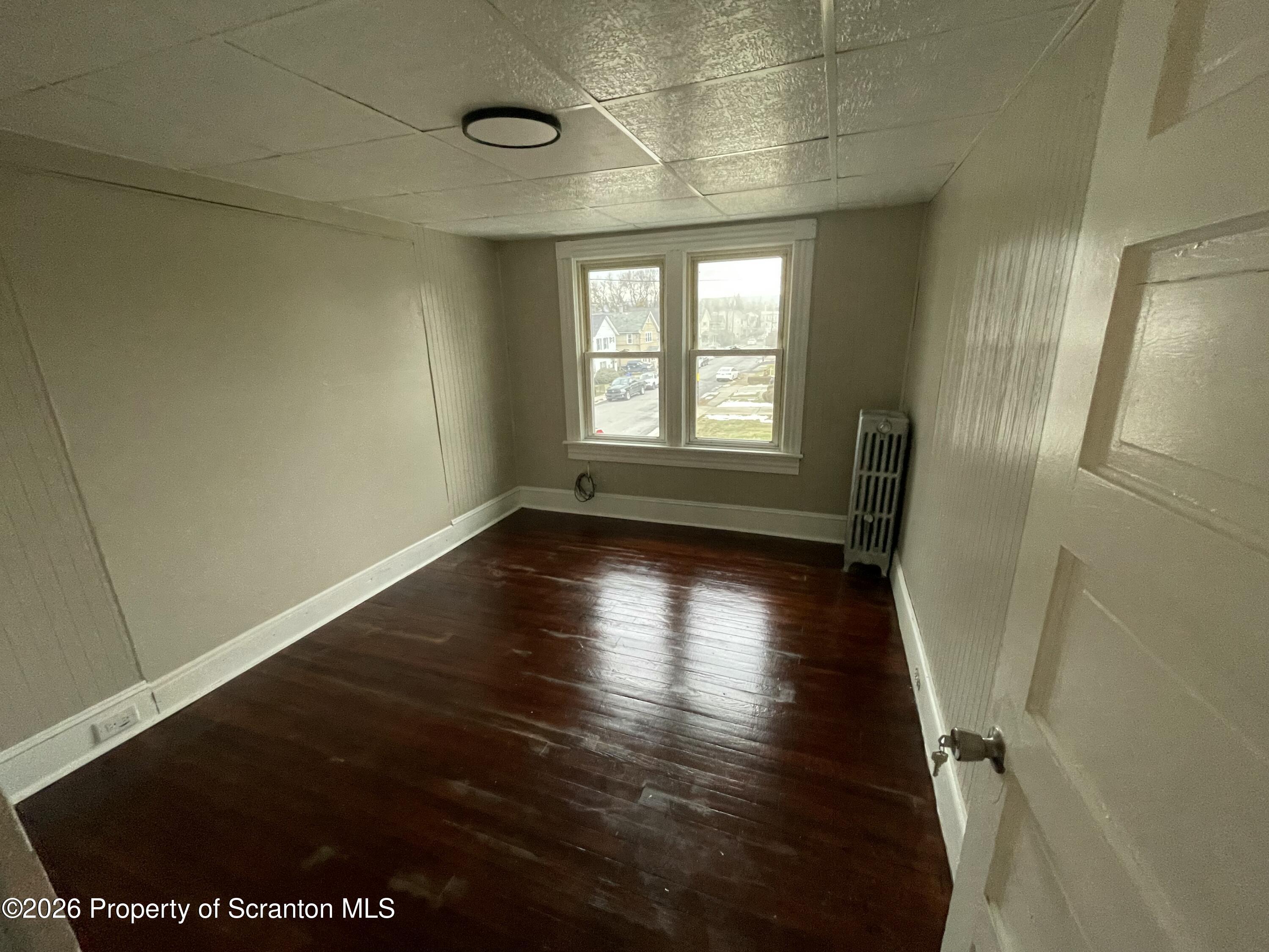 401 Putnam Street Scranton, PA 18508 - Photo 26 of 29 a view of an empty room with wooden floor and a window