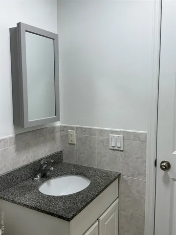 a bathroom with a granite countertop sink and a mirror