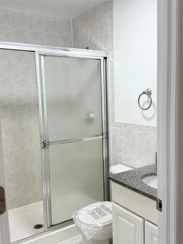 a bathroom with a granite countertop shower and a sink