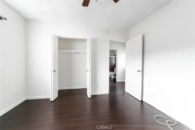 a view of a big room with wooden floor and windows