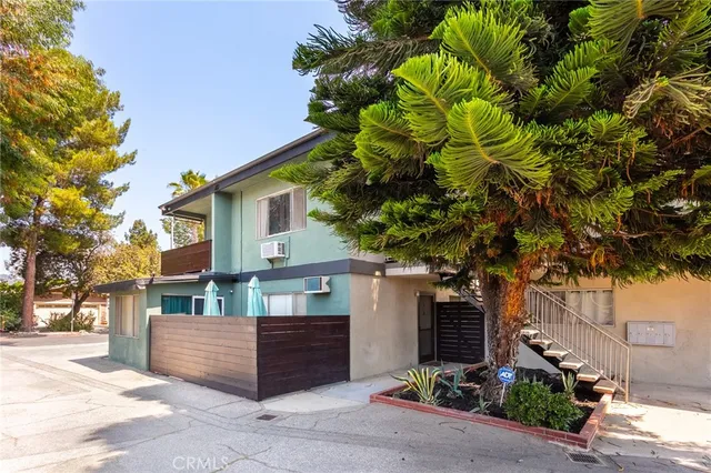 a front view of a house with a tree