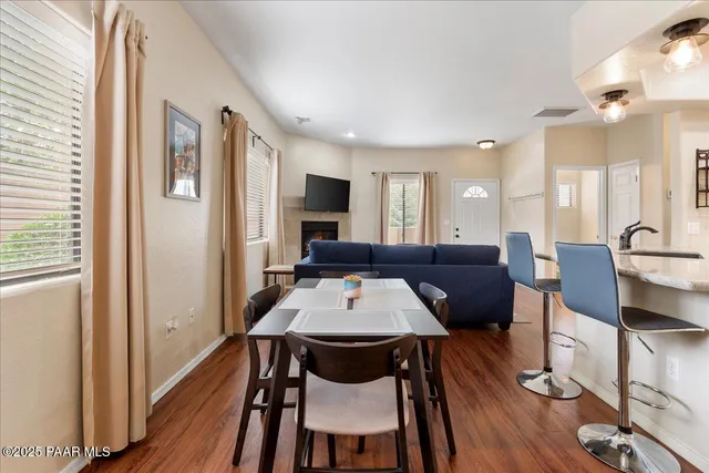 a living room with furniture a wooden floor and next to a window