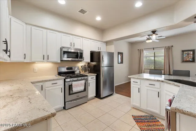 a kitchen with granite countertop a sink stainless steel appliances and cabinets