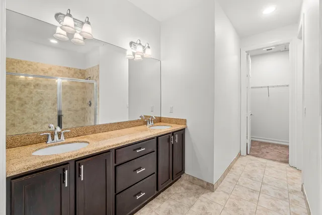 a bathroom with a double vanity sink a mirror and a shower
