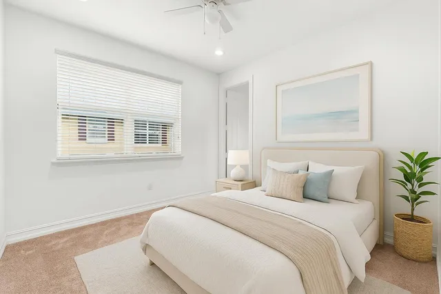 a bedroom with a large bed and a potted plant