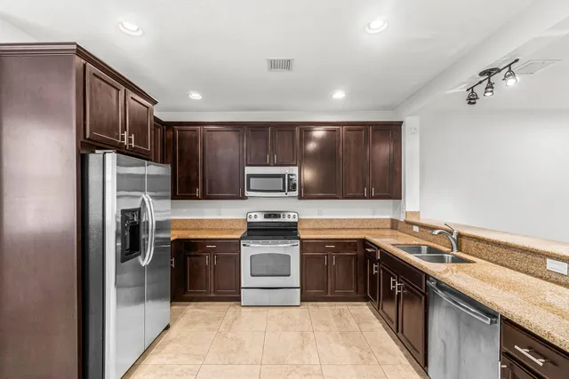 a kitchen with stainless steel appliances granite countertop a sink stove and refrigerator