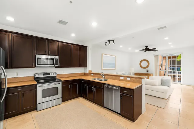 a kitchen with stainless steel appliances granite countertop a stove sink and cabinets