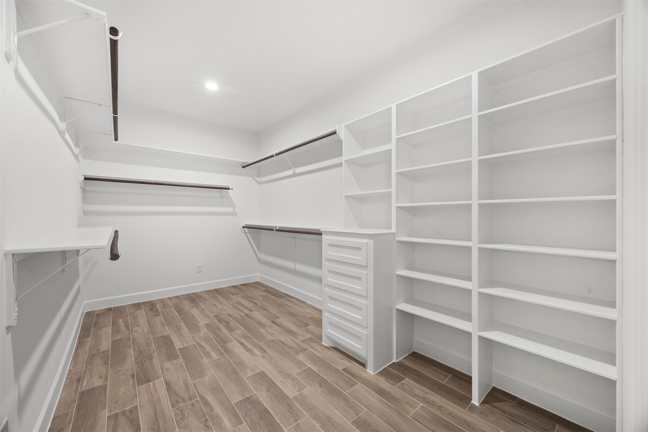 183 Windmill Road Huntsville, TX 77340 - Photo 22 of 47 Primary bedroom closet with tons of shelving, drawers and hanging pole spaces.