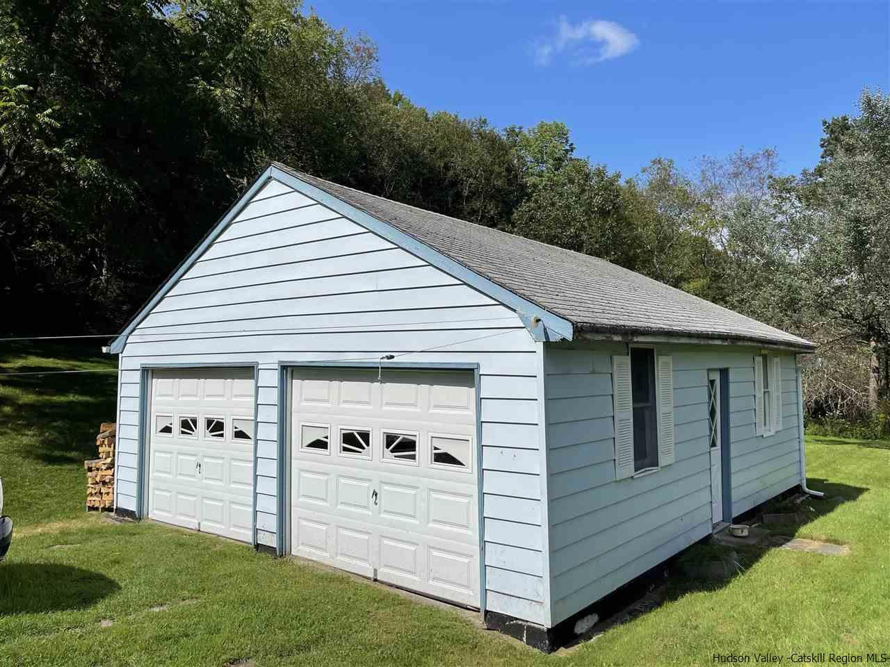 6277 County Rt 36 Denver, NY 12421 - Photo 5 of 27 a view of a white house with a big yard and potted plants