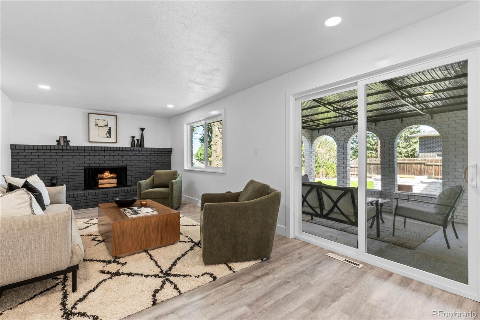 700 Busch Street Longmont, CO 80501 - Photo 11 of 27 a living room with furniture a fireplace and a floor to ceiling window