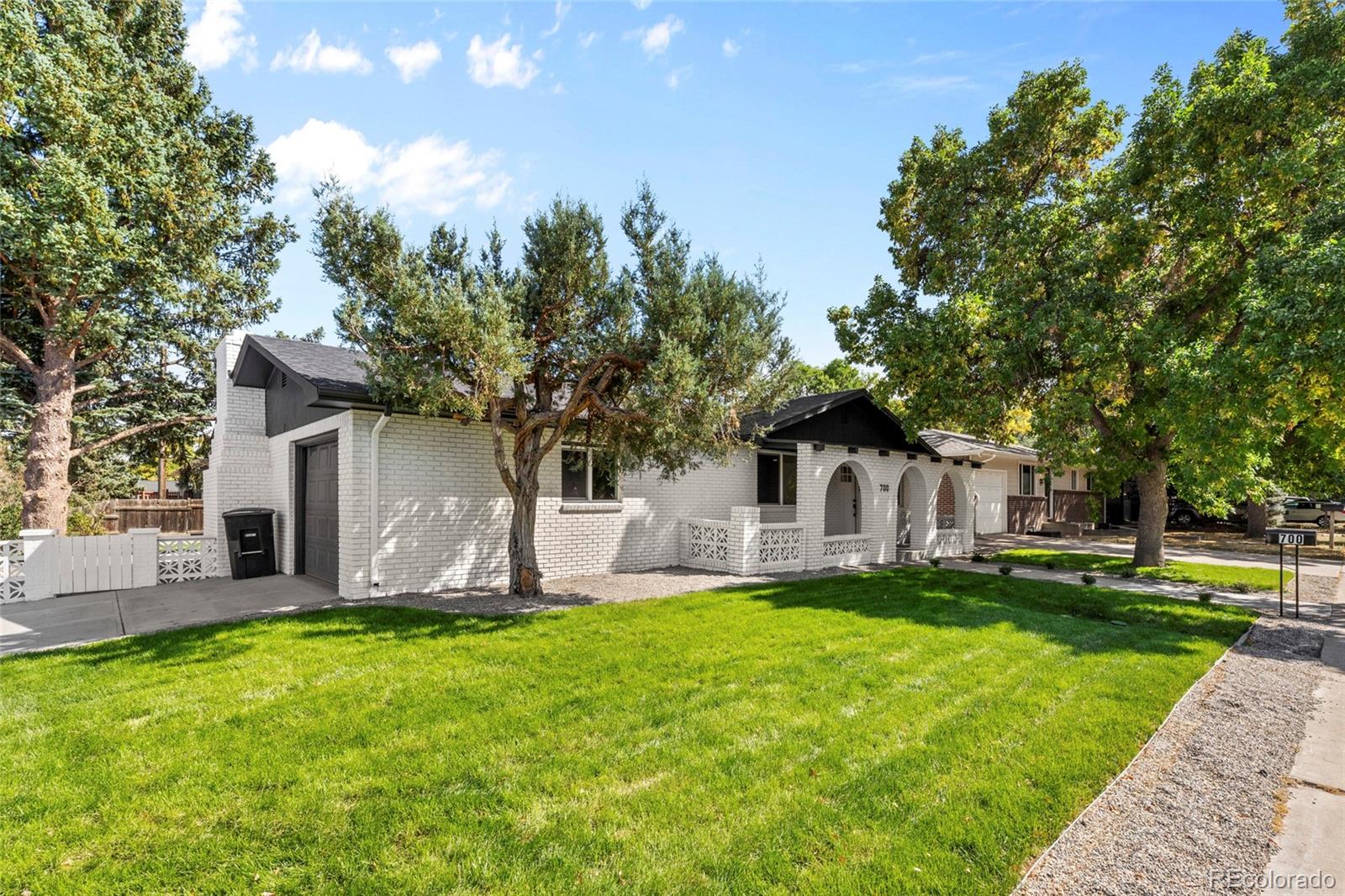 700 Busch Street Longmont, CO 80501 - Photo 27 of 27 a large tree in front of a house with a yard
