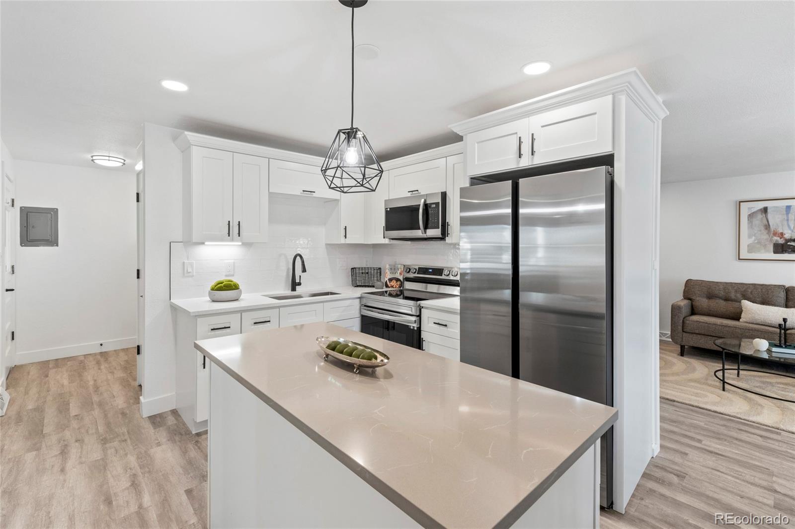 700 Busch Street Longmont, CO 80501 - Photo 7 of 27 a kitchen with a refrigerator a sink dishwasher a stove and white cabinets with wooden floor