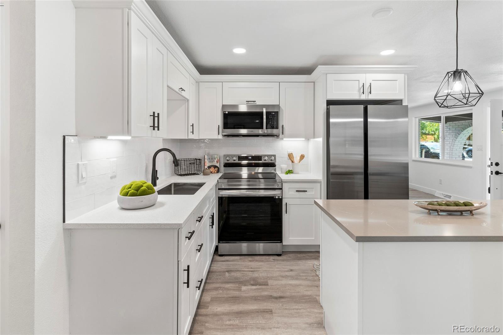 700 Busch Street Longmont, CO 80501 - Photo 8 of 27 a kitchen with a sink a counter top space stainless steel appliances and cabinets