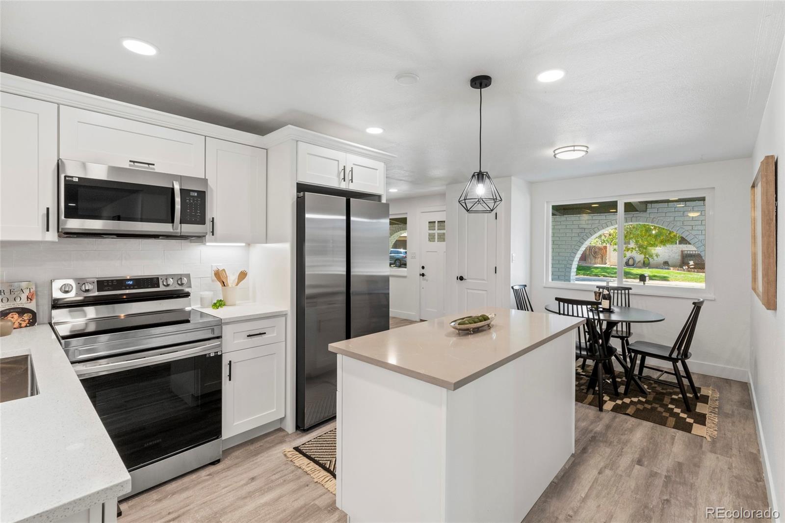 700 Busch Street Longmont, CO 80501 - Photo 10 of 27 a kitchen with stainless steel appliances a stove a sink dishwasher a refrigerator white cabinets and wooden floor