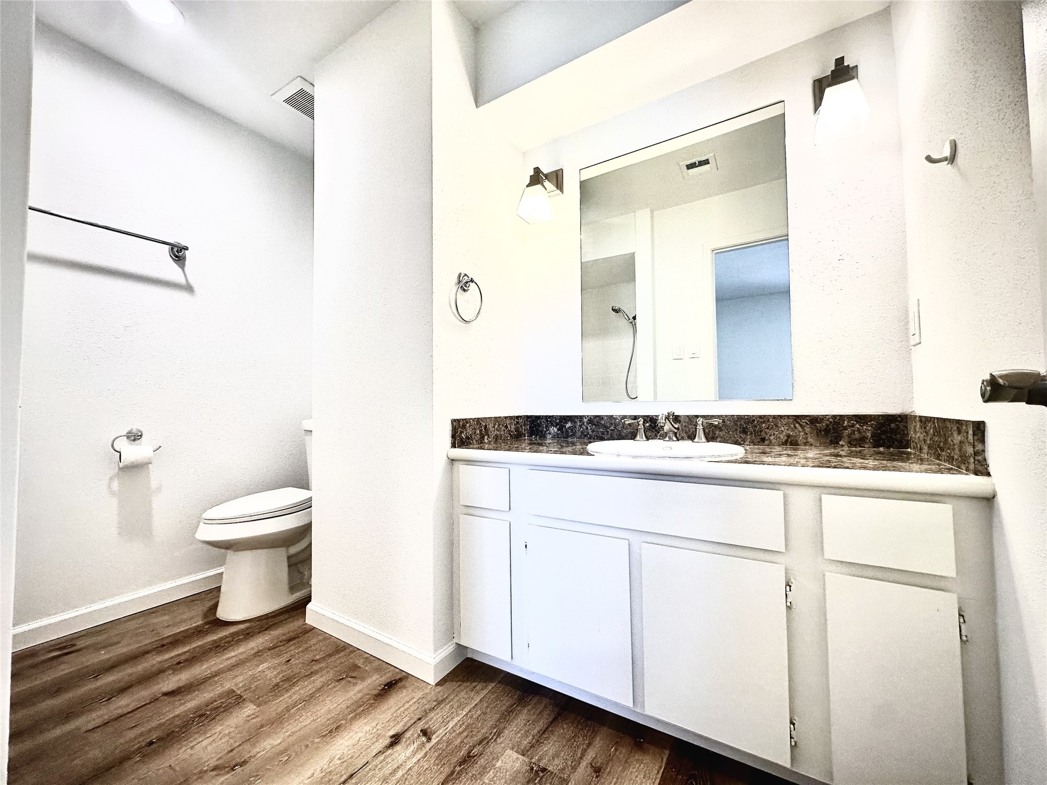 14771 Perthshire Road Houston, TX 77079 - Photo 13 of 23 a bathroom with a granite countertop toilet a sink and a mirror