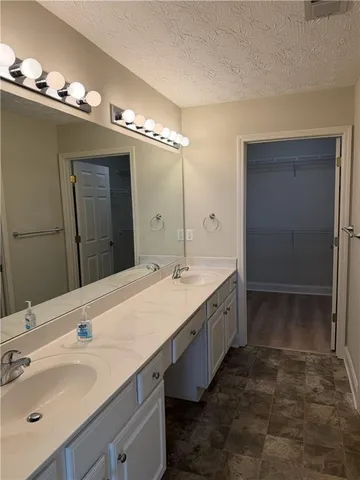 a spacious bathroom with a double vanity sink and a mirror